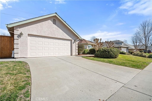 single story home featuring driveway, stucco siding, an attached garage, fence, and a front yard