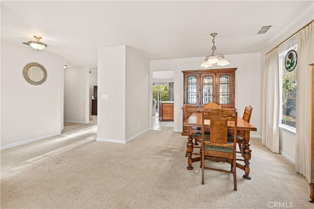 dining area featuring light carpet, visible vents, and baseboards