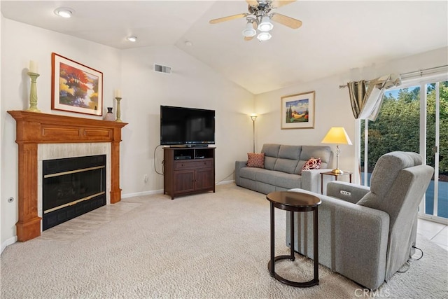 living area featuring light carpet, visible vents, a ceiling fan, a tile fireplace, and lofted ceiling