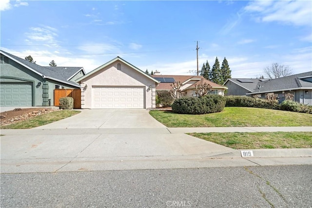 single story home featuring an attached garage, fence, driveway, stucco siding, and a front lawn