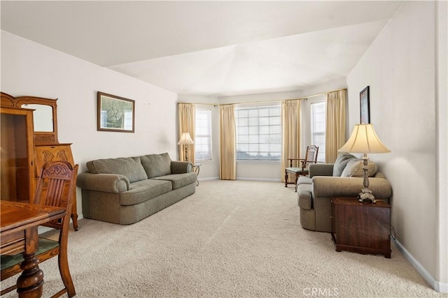 living room featuring plenty of natural light, baseboards, and light colored carpet