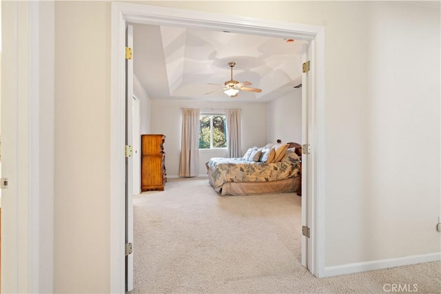 bedroom featuring a ceiling fan, carpet, a raised ceiling, and baseboards