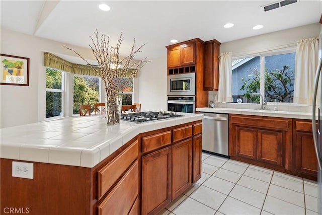 kitchen featuring tile countertops, light tile patterned flooring, recessed lighting, visible vents, and appliances with stainless steel finishes