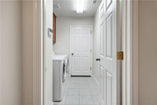 washroom with cabinet space, visible vents, washing machine and clothes dryer, and light tile patterned floors