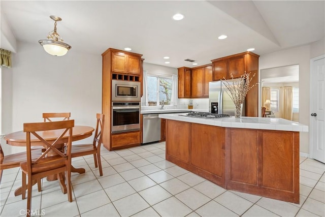 kitchen featuring light tile patterned flooring, recessed lighting, stainless steel appliances, a center island, and brown cabinets