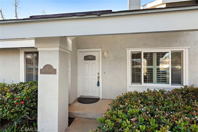 property entrance with stucco siding