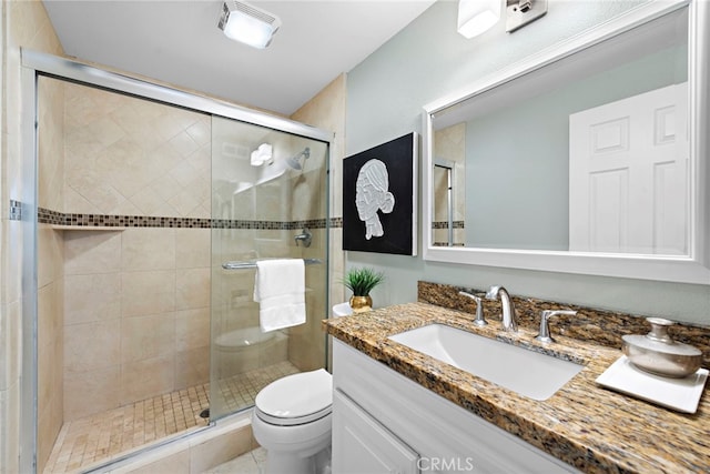 bathroom featuring a stall shower, vanity, and toilet