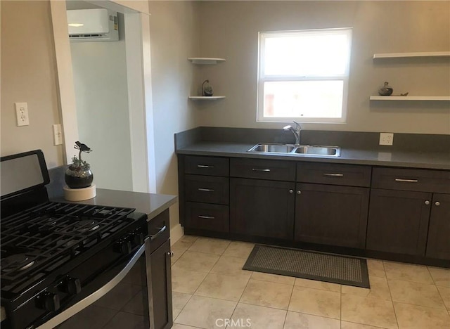 kitchen with dark brown cabinetry, stainless steel gas range, a sink, and a wall mounted AC