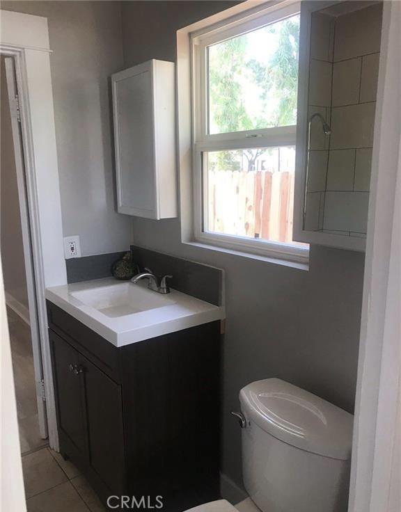 bathroom featuring vanity, tile patterned flooring, and toilet