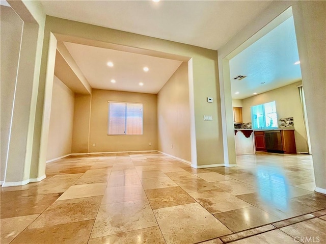 spare room featuring recessed lighting and baseboards