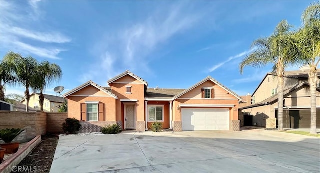 view of front of house with driveway, an attached garage, fence, and brick siding