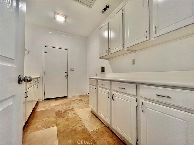 laundry area featuring stone finish floor, cabinet space, hookup for a washing machine, and visible vents