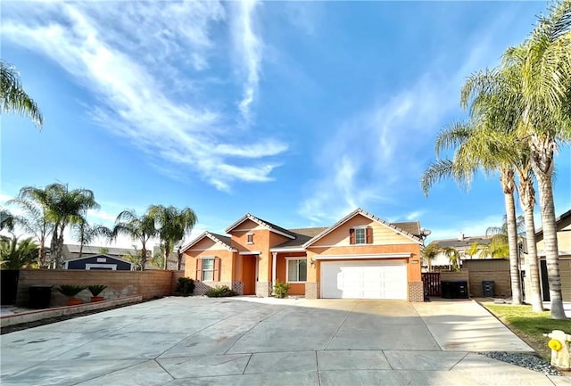 view of front of house featuring a garage, driveway, fence, and stucco siding