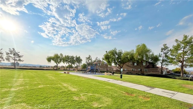 view of home's community with playground community and a yard