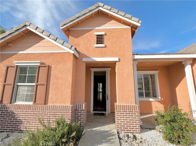 view of exterior entry with stucco siding