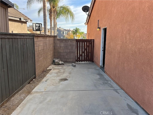 view of home's exterior with a patio area, fence, a gate, and stucco siding