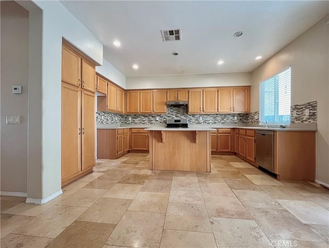 kitchen featuring visible vents, a kitchen island, appliances with stainless steel finishes, light countertops, and backsplash