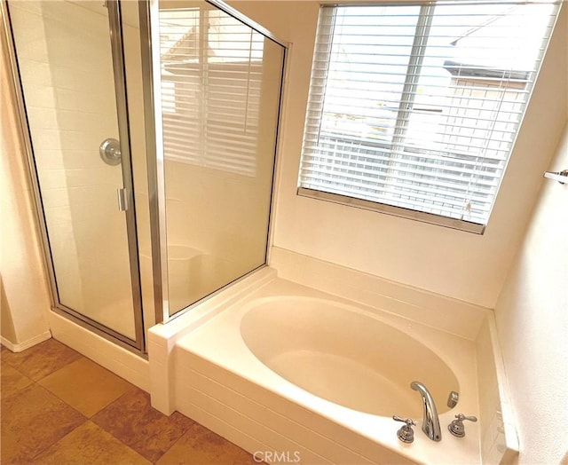 bathroom featuring a stall shower and a bath