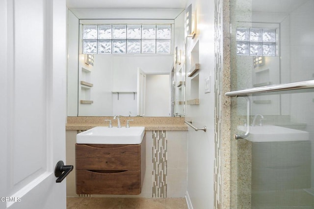 bathroom with a shower stall and vanity