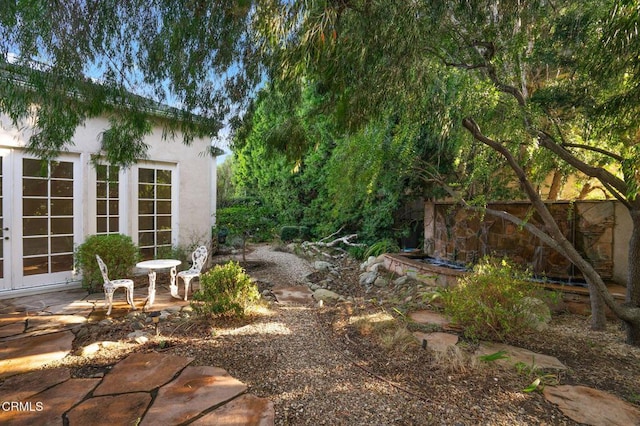 view of yard featuring a patio area and french doors