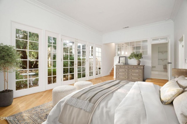 bedroom featuring light wood-type flooring, visible vents, and crown molding