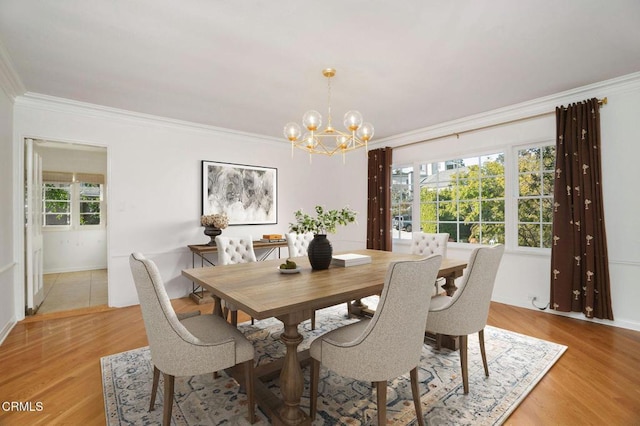 dining area featuring ornamental molding, wood finished floors, and a notable chandelier