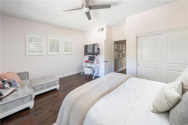 bedroom featuring baseboards, visible vents, a ceiling fan, dark wood finished floors, and a closet