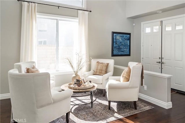 sitting room featuring baseboards, dark wood finished floors, and a wealth of natural light