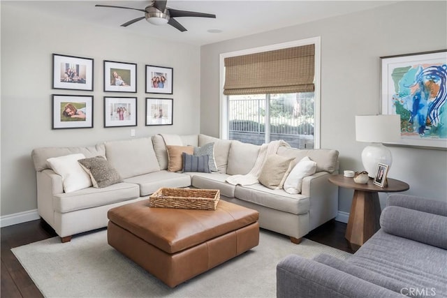 living area with ceiling fan, baseboards, and wood finished floors