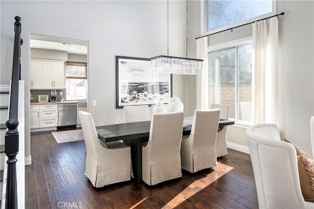 dining area with a healthy amount of sunlight, an inviting chandelier, baseboards, and dark wood finished floors