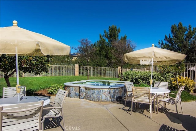 view of patio / terrace featuring an in ground hot tub, a fenced backyard, and outdoor dining space