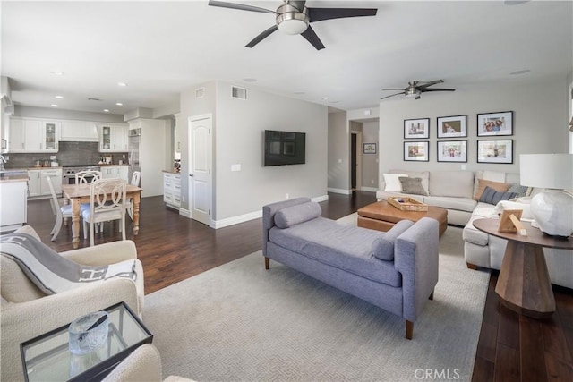 living room featuring baseboards, visible vents, dark wood finished floors, and recessed lighting