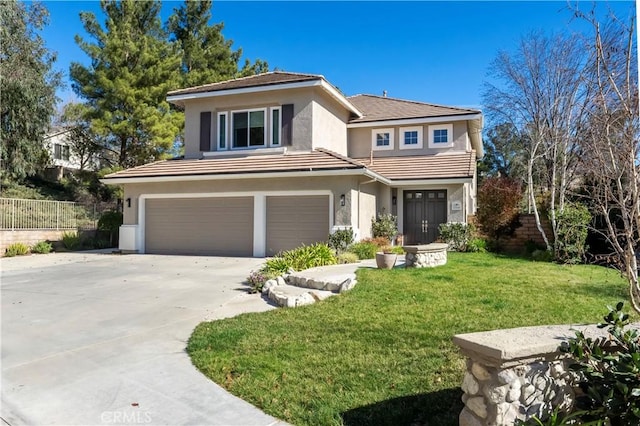 prairie-style home with a garage, concrete driveway, fence, a front yard, and stucco siding