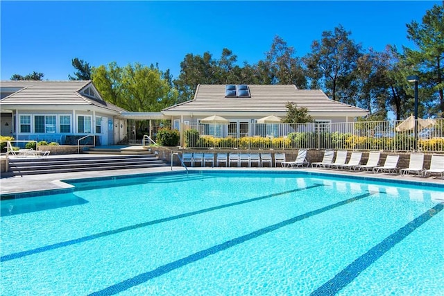 view of swimming pool featuring fence