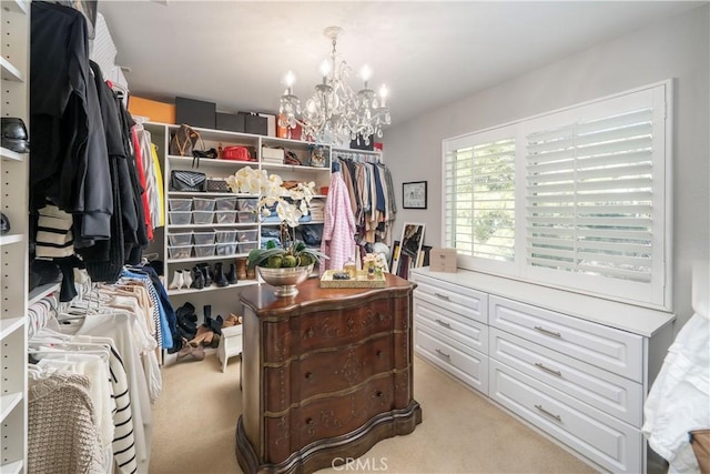 walk in closet featuring light carpet and a chandelier