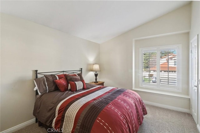 bedroom featuring lofted ceiling, carpet floors, and baseboards