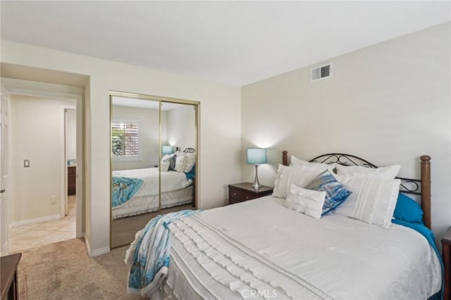 bedroom with light carpet, baseboards, visible vents, and a closet