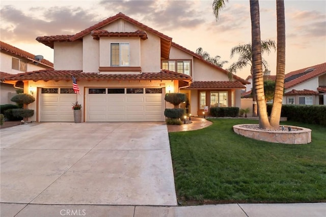 mediterranean / spanish house with an attached garage, concrete driveway, a front yard, and a tiled roof