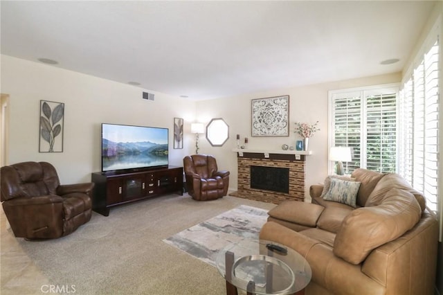 living area with a fireplace, visible vents, and light colored carpet