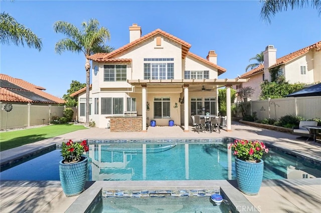 rear view of property featuring a patio area, a fenced backyard, a fenced in pool, and stucco siding