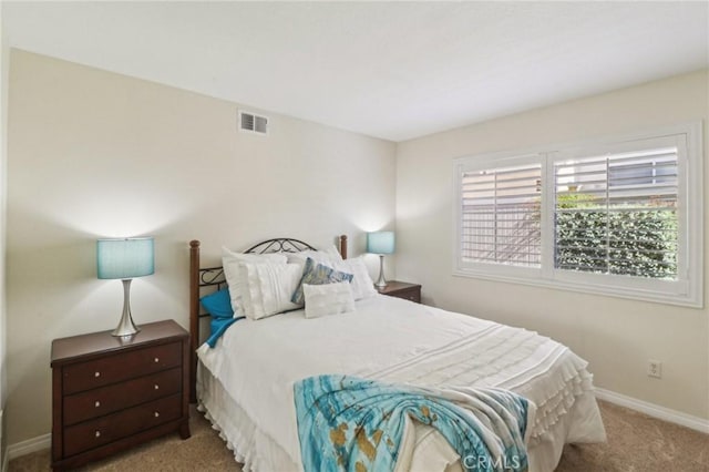 carpeted bedroom featuring visible vents and baseboards