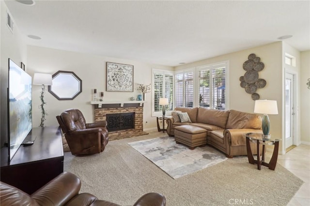 living room with a brick fireplace, visible vents, light carpet, and baseboards