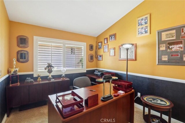 office with lofted ceiling and light colored carpet