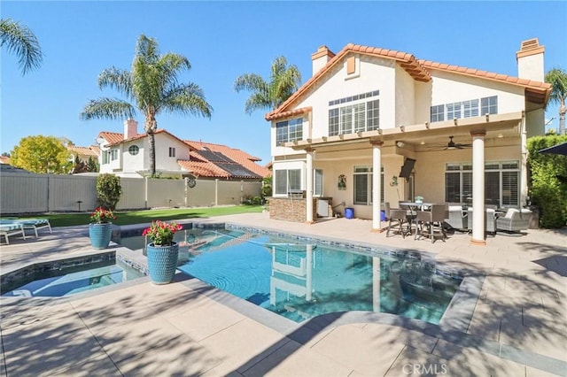 rear view of house featuring a fenced in pool, a fenced backyard, a chimney, and a ceiling fan