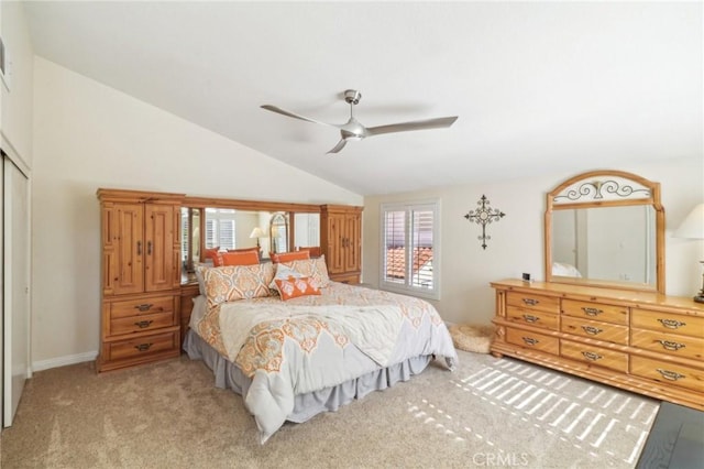 bedroom featuring baseboards, a ceiling fan, light colored carpet, lofted ceiling, and a closet