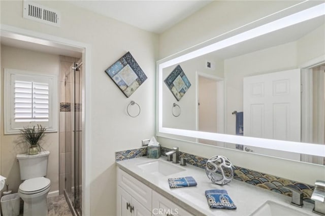 full bathroom with double vanity, a shower stall, visible vents, and a sink