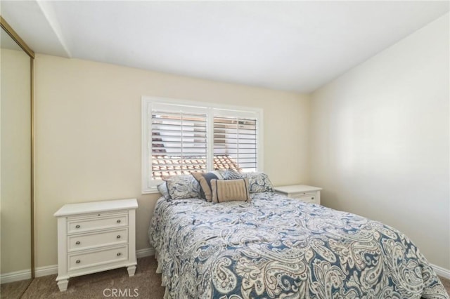 bedroom featuring dark colored carpet and baseboards