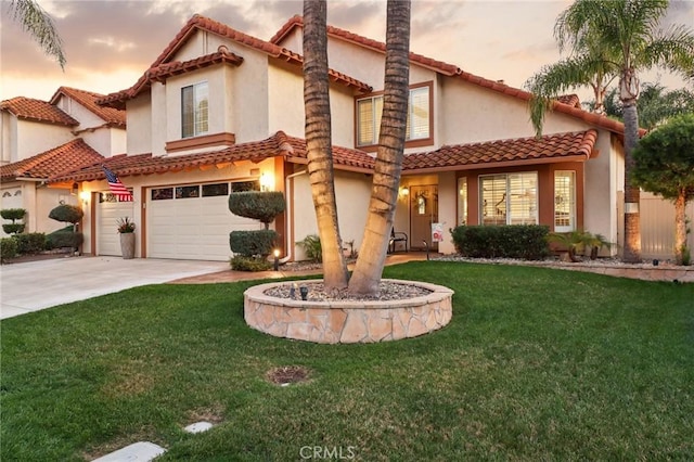 mediterranean / spanish-style home featuring an attached garage, stucco siding, driveway, and a front yard