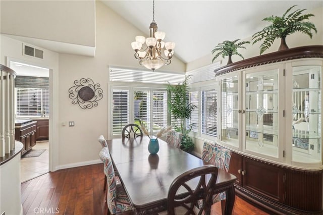 dining space featuring baseboards, visible vents, dark wood finished floors, vaulted ceiling, and a notable chandelier