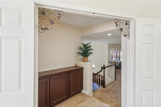 hall with light carpet and an upstairs landing